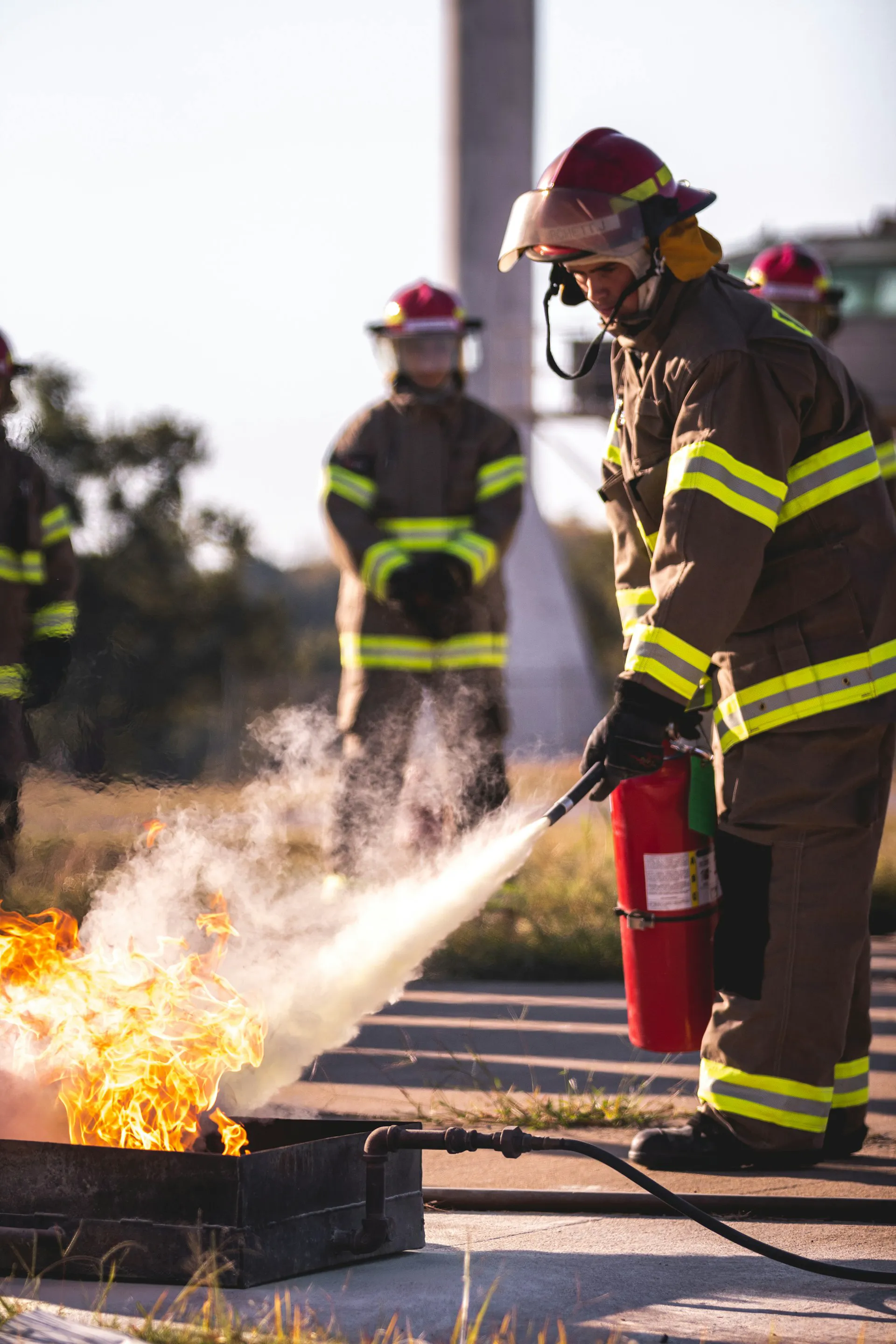 Firefighter using a fire extinguisher to control flames during a training session