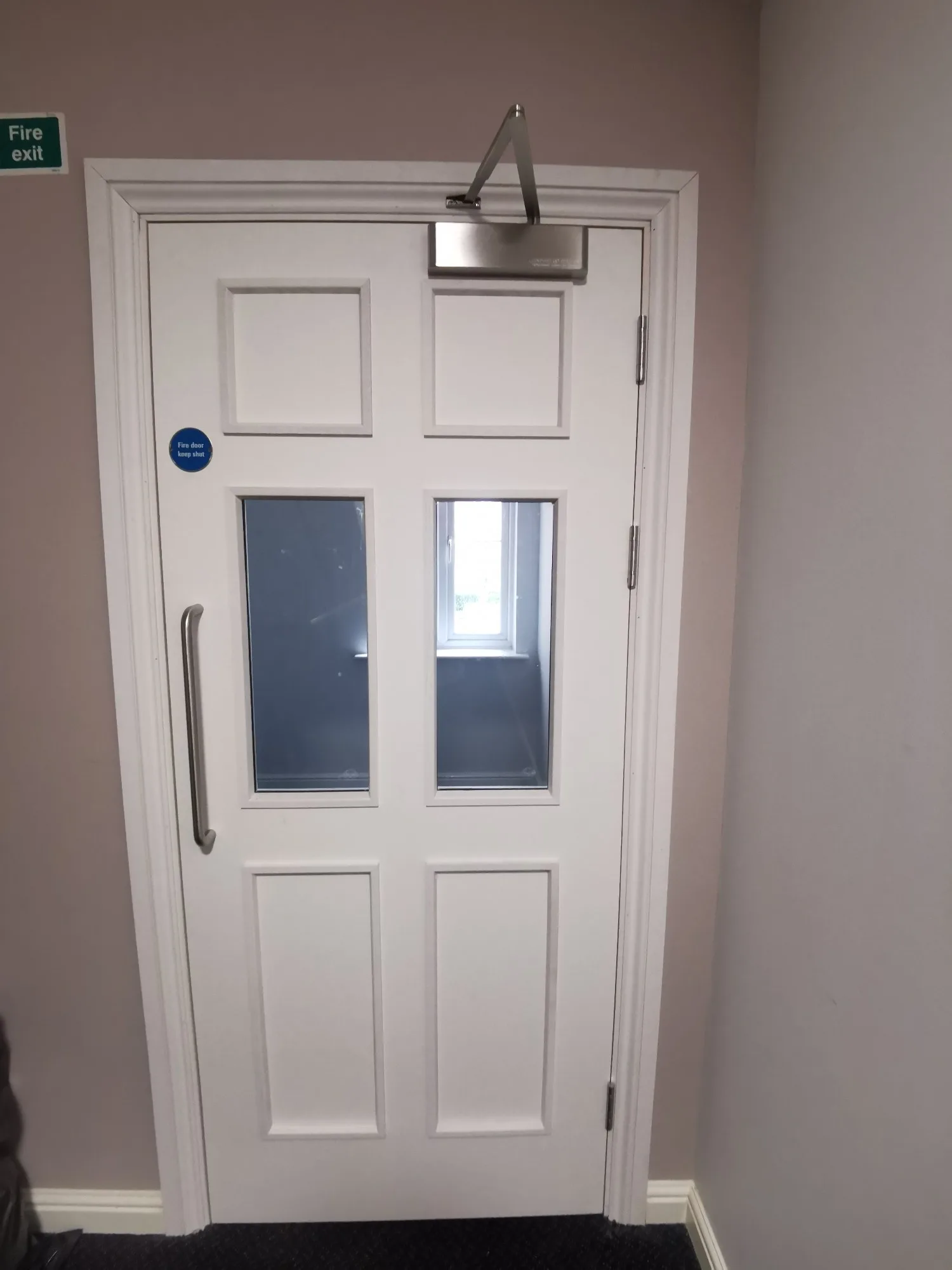White fire door with glass panels and exit signage
