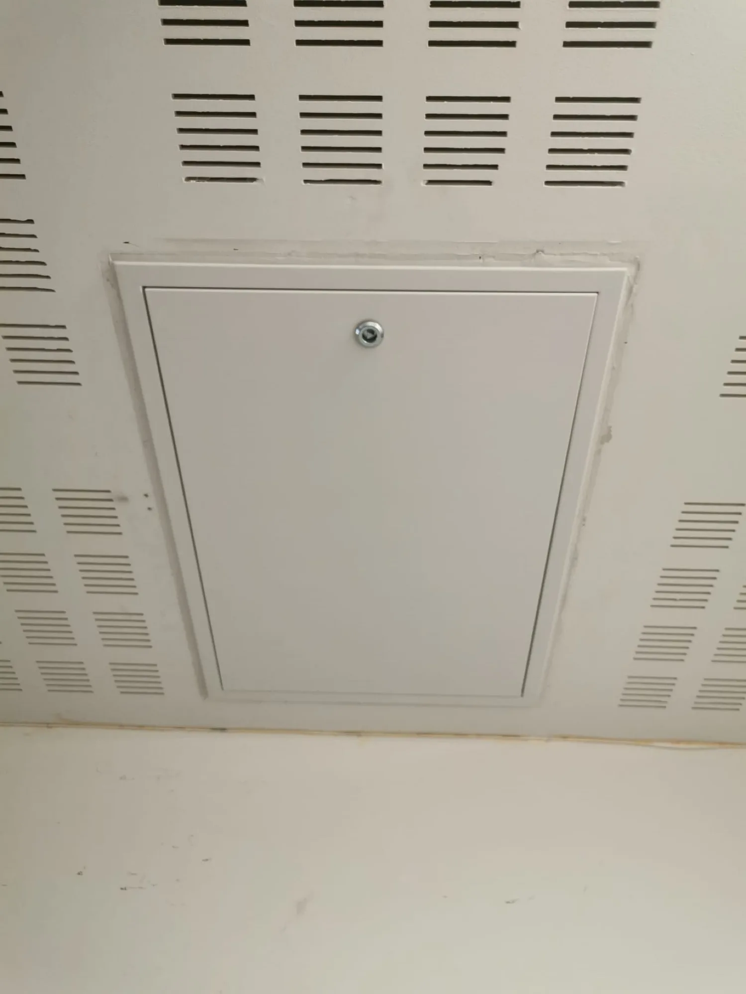 White loft hatch installed in a ceiling, designed for access to hidden spaces