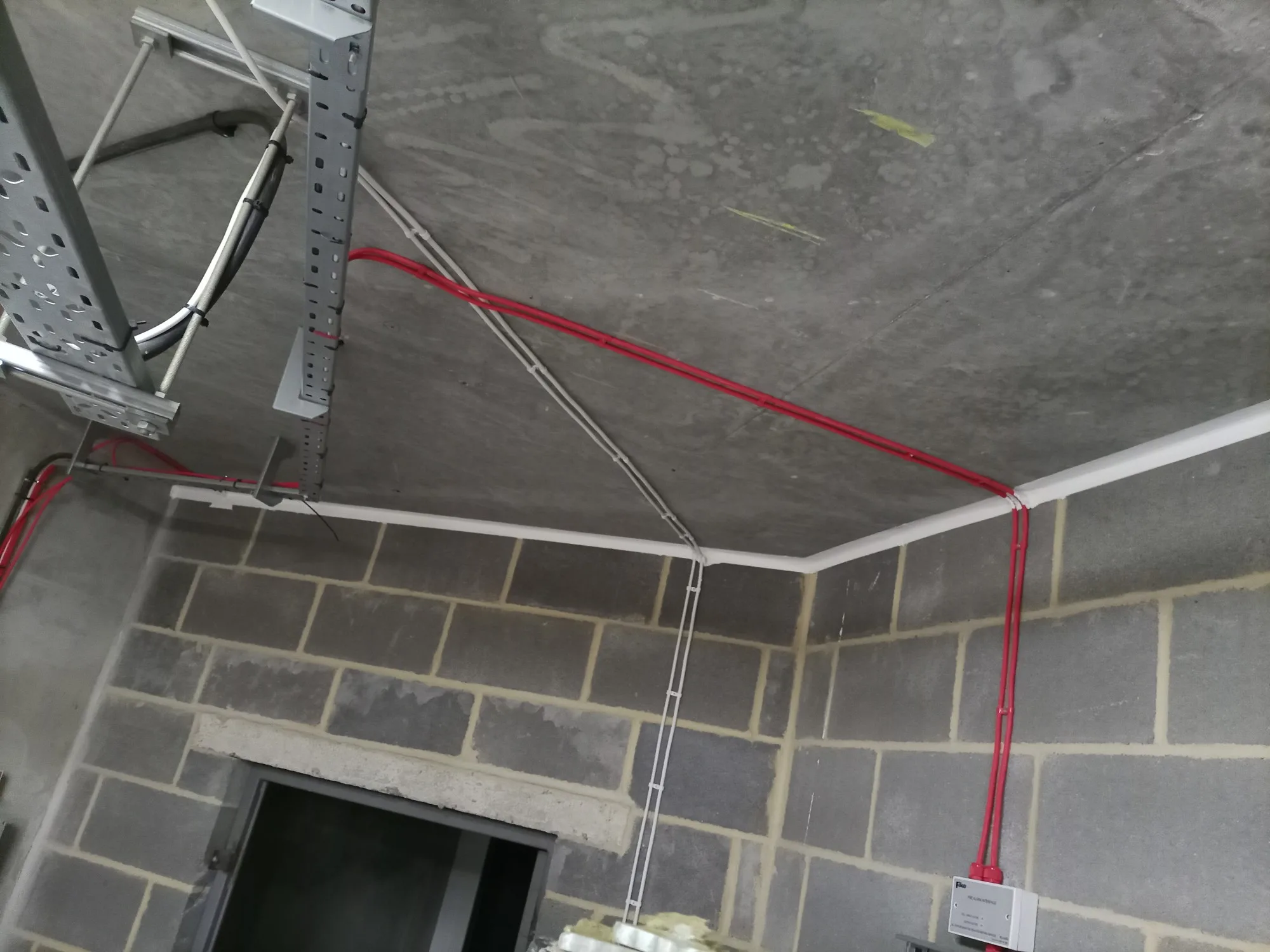Red fire protection pipes installed on a concrete ceiling for effective fire stopping services