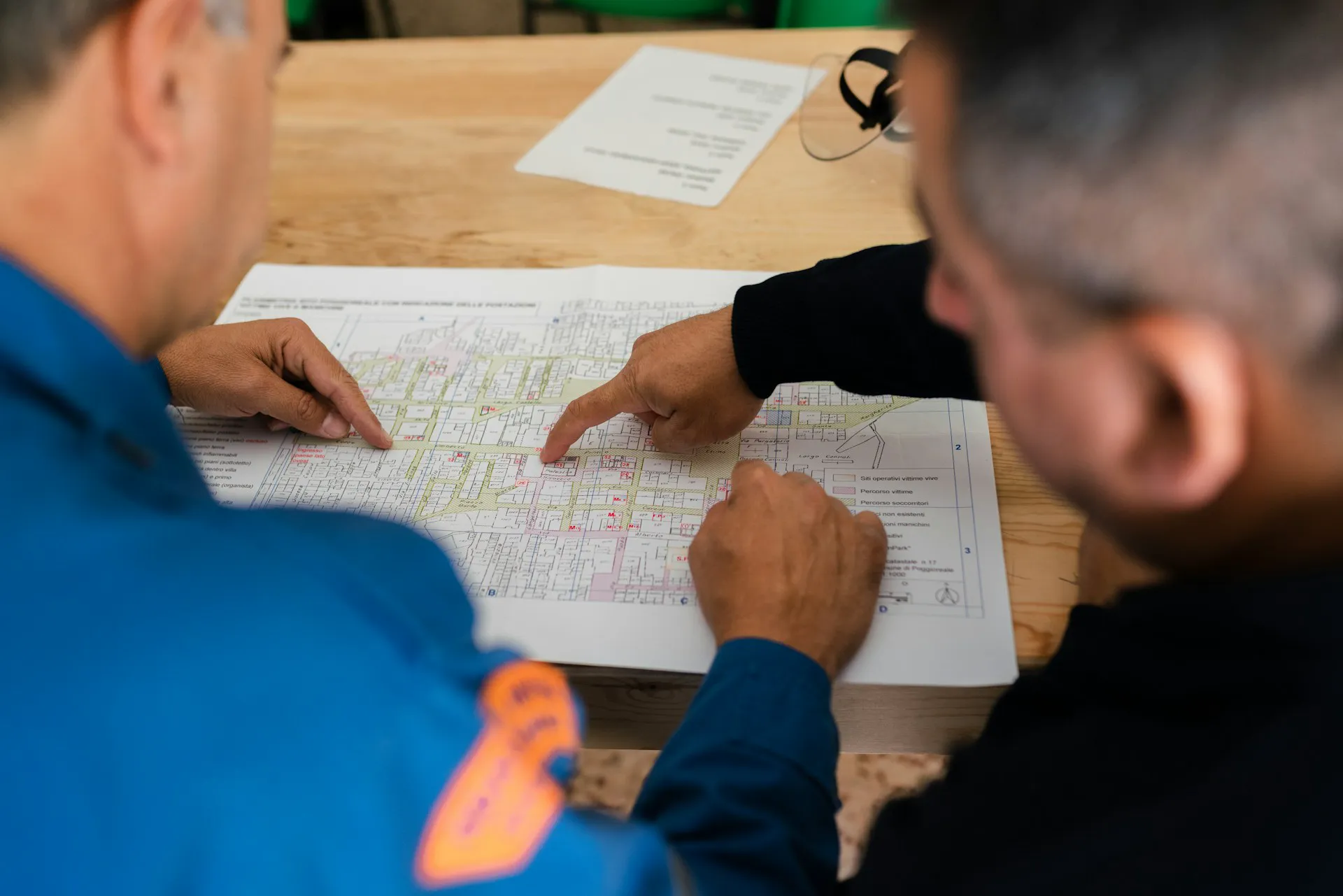 Two professionals discussing fire compartmentation plans on a printed map